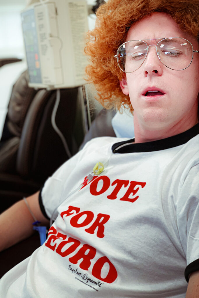 Rex Jones, a lymphoma cancer patient undergoing chemotherapy dressed in a humorous “Vote for Pedro” chemo costume, bringing lightness to the treatment experience.