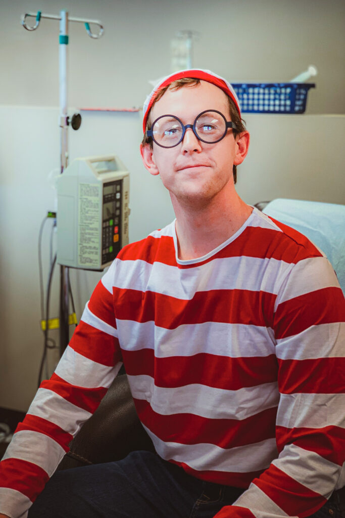 Rex Jones, a lymphoma cancer patient undergoing chemotherapy dressed in a “Where’s Waldo” chemo costume, adding humor to the treatment experience.