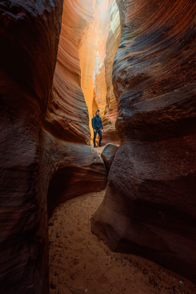 Rex Jones captured in a stunning Utah slot canyon, showcasing commercial photography with a focus on adventure and nature exploration.